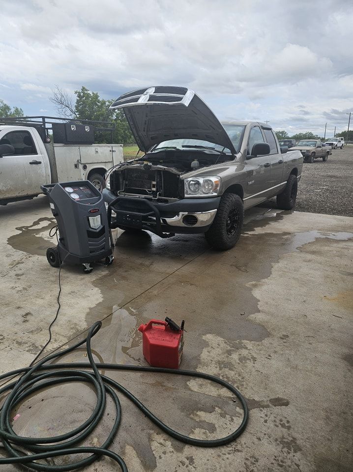 A truck with its hood up is parked in a parking lot.