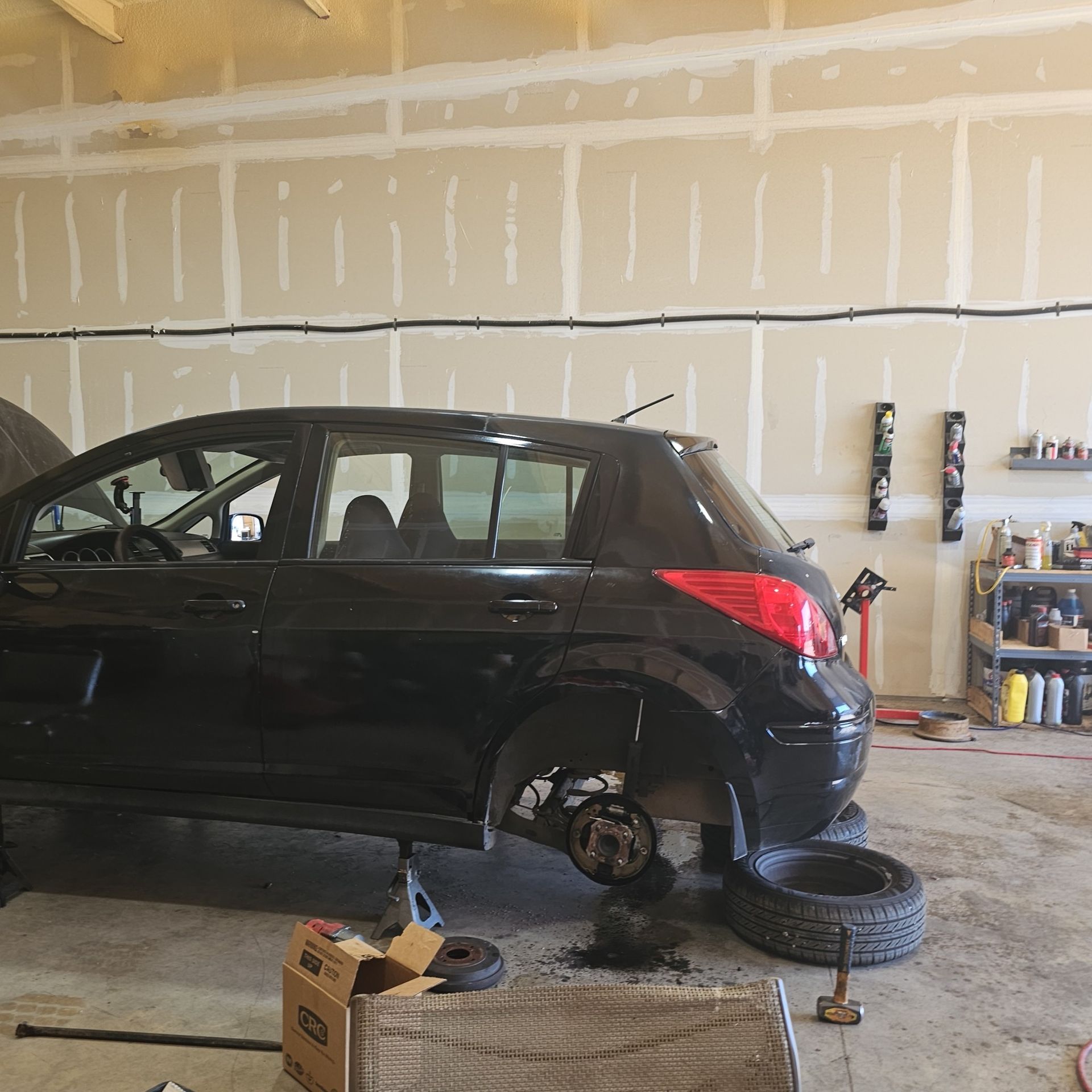 A black car is being worked on in a garage