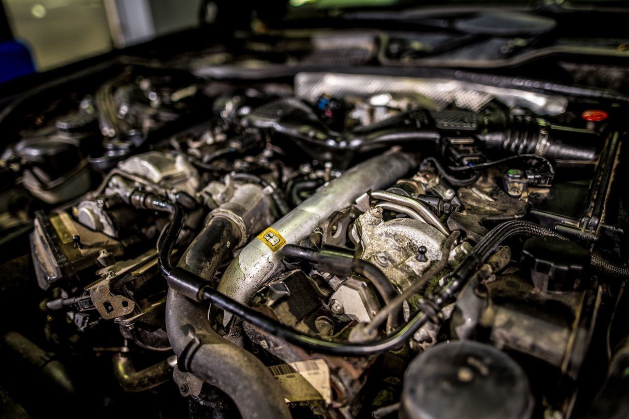 A close up of a car engine with the hood open.