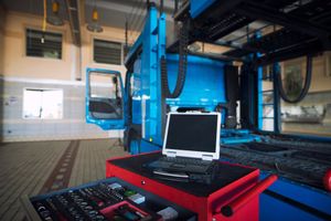 A laptop is sitting on top of a toolbox in a garage.