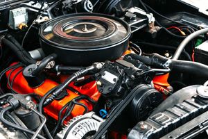 A close up of a car engine with a air filter.