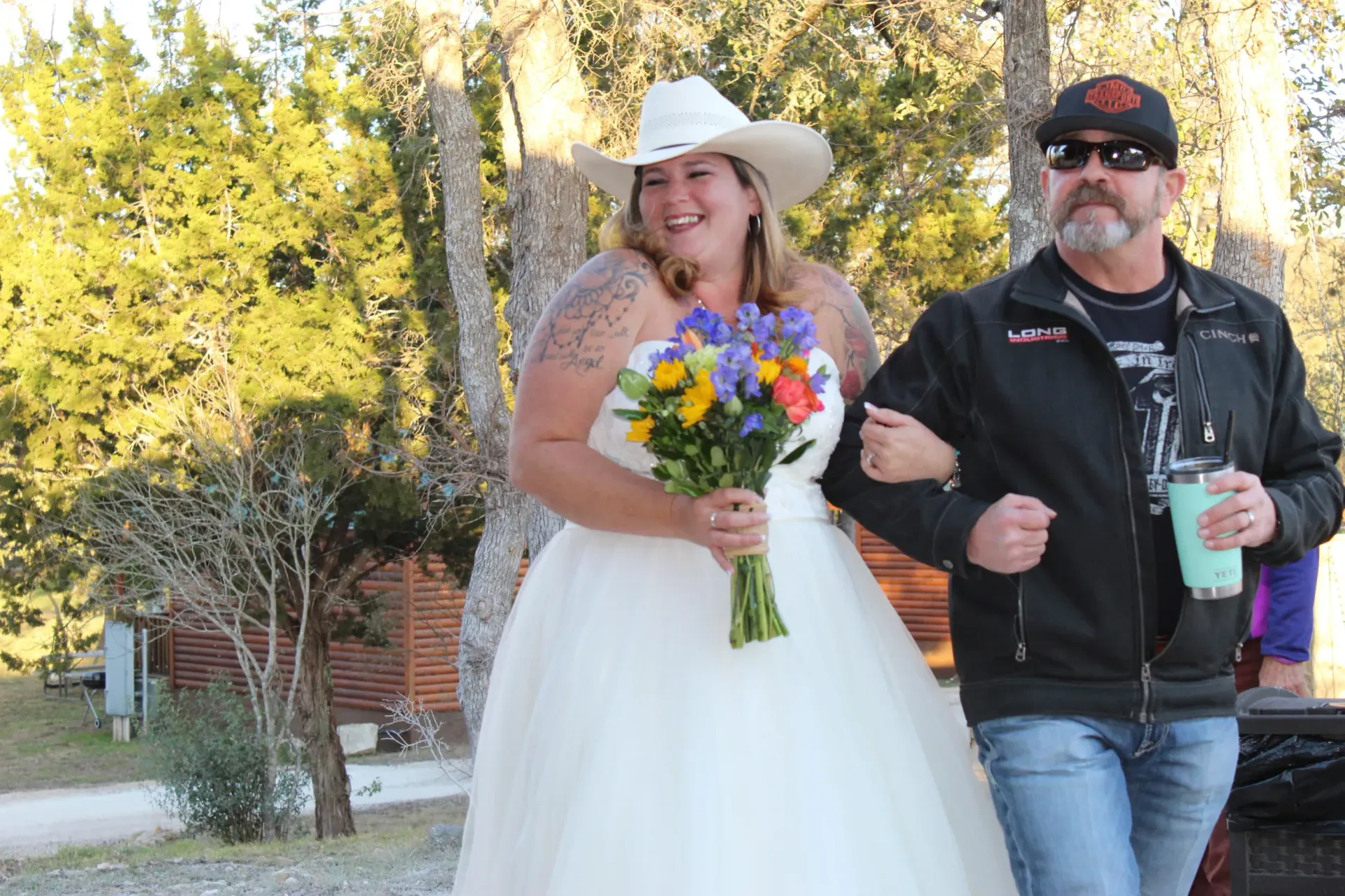 A man is walking a bride down the aisle at a wedding.