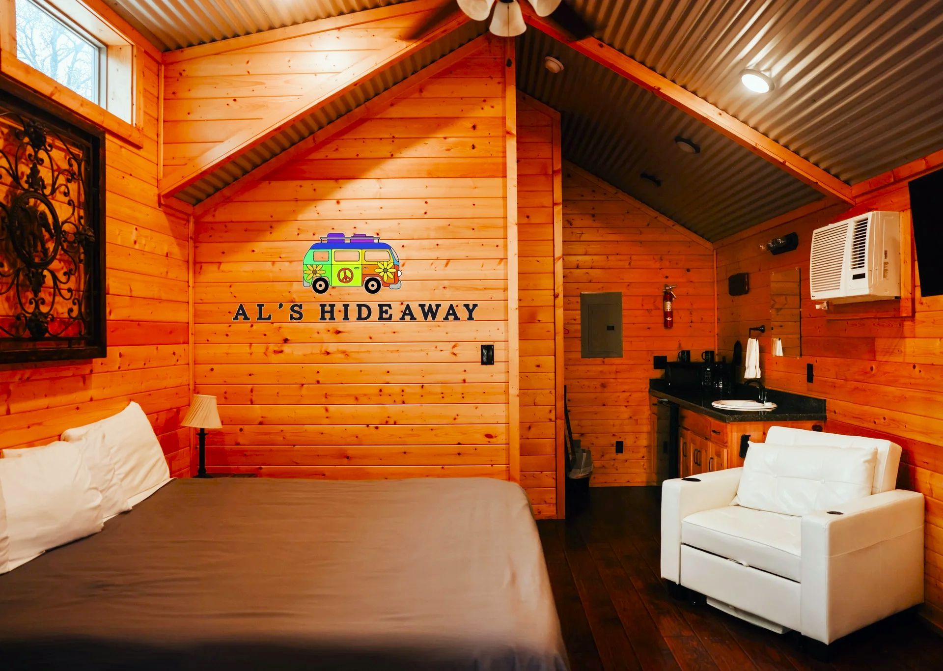 A bedroom with a bed , chair and a sign that says all 's hideaway