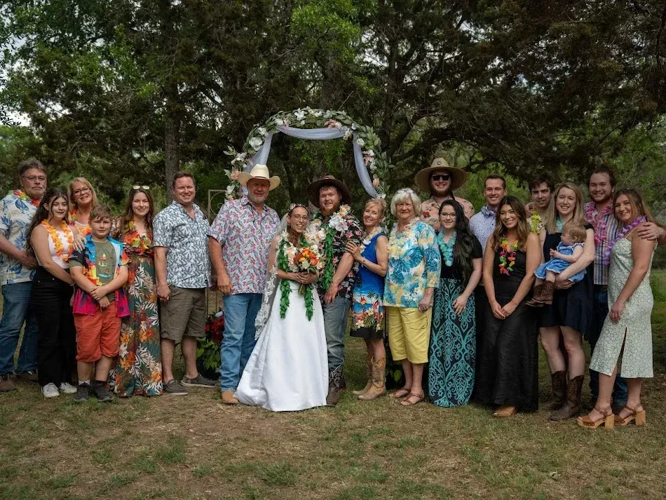 A large group of people are posing for a picture at a wedding.
