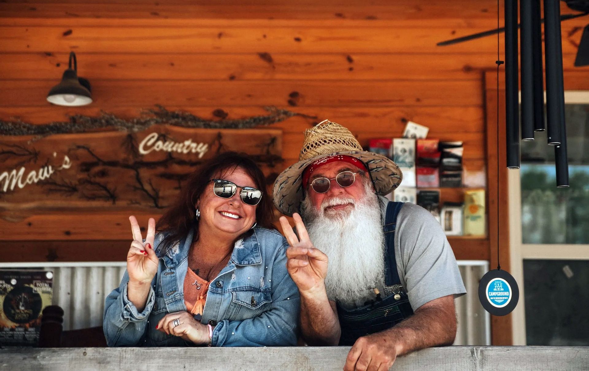 A man and a woman are posing for a picture and giving peace signs.