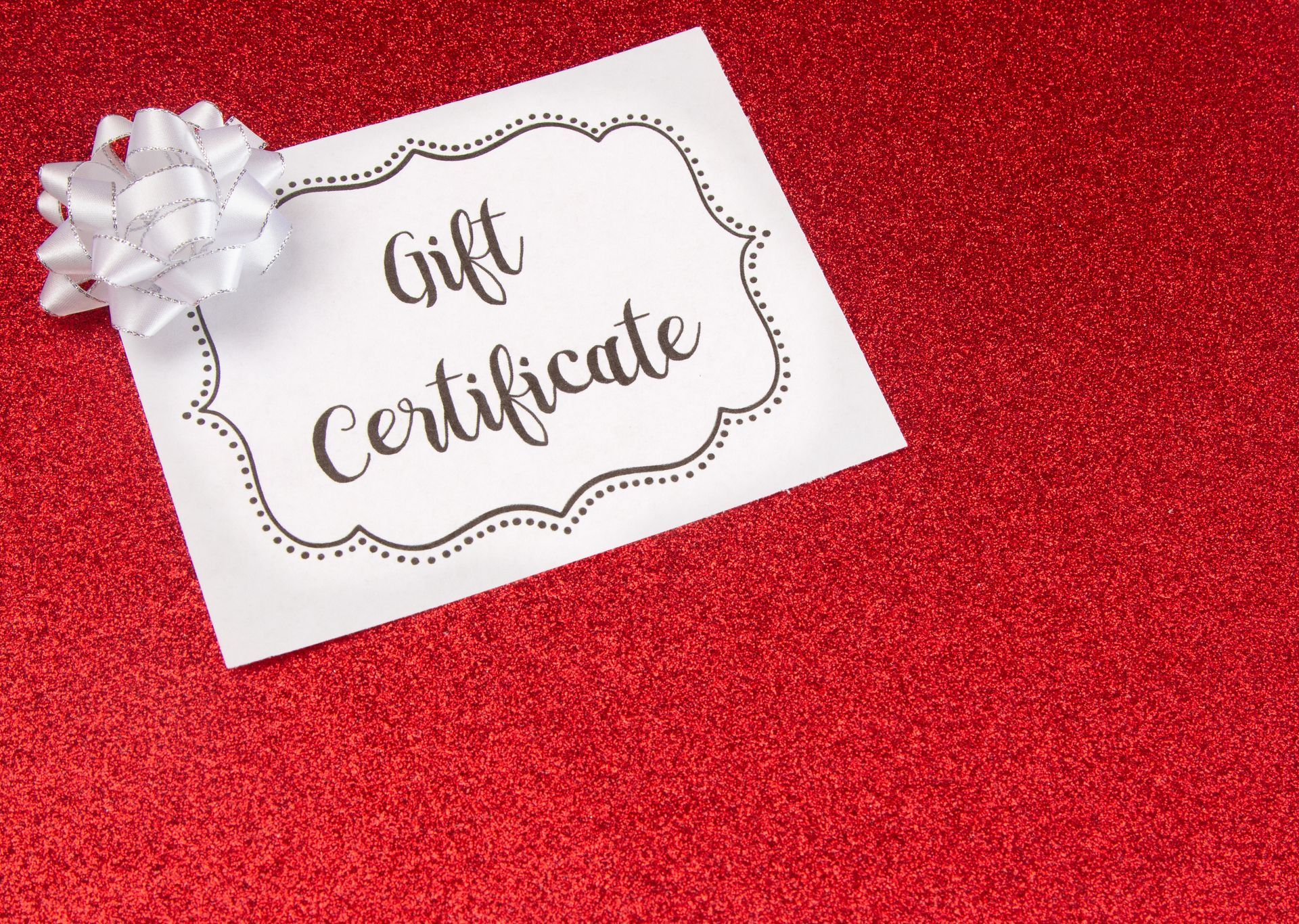 A gift certificate with a bow on a red background.