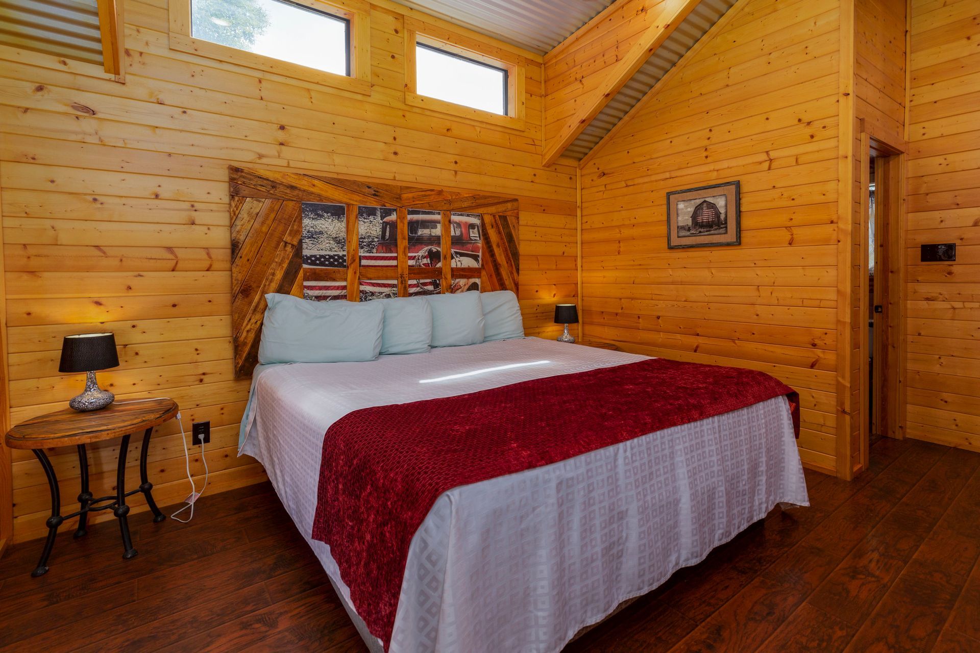 A bedroom in a log cabin with a king size bed and a wooden headboard.