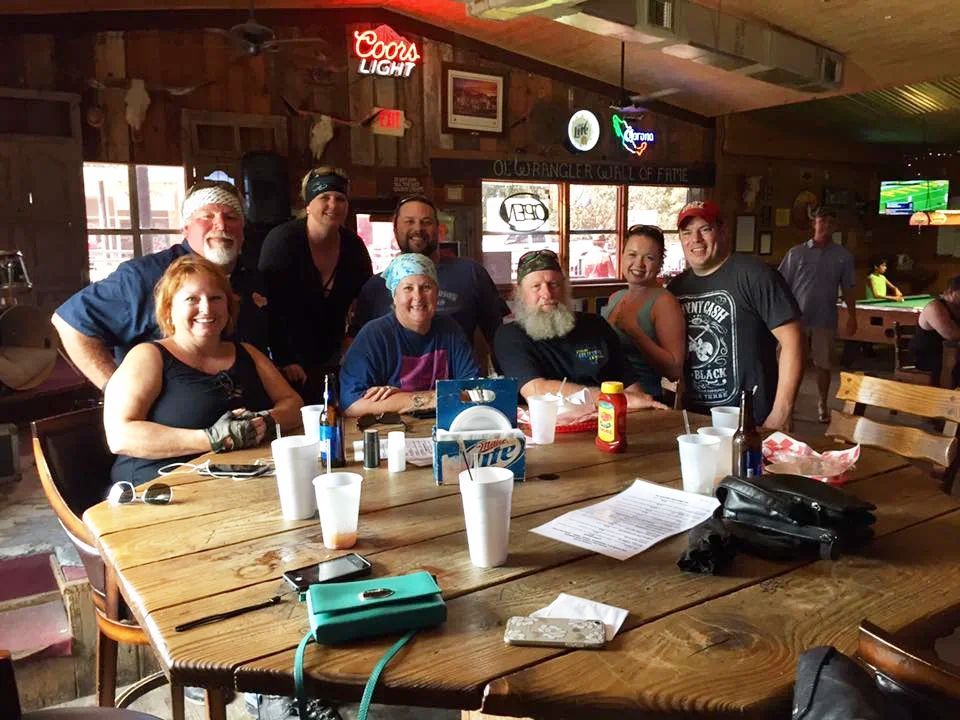 A group of people are sitting around a table in a restaurant.