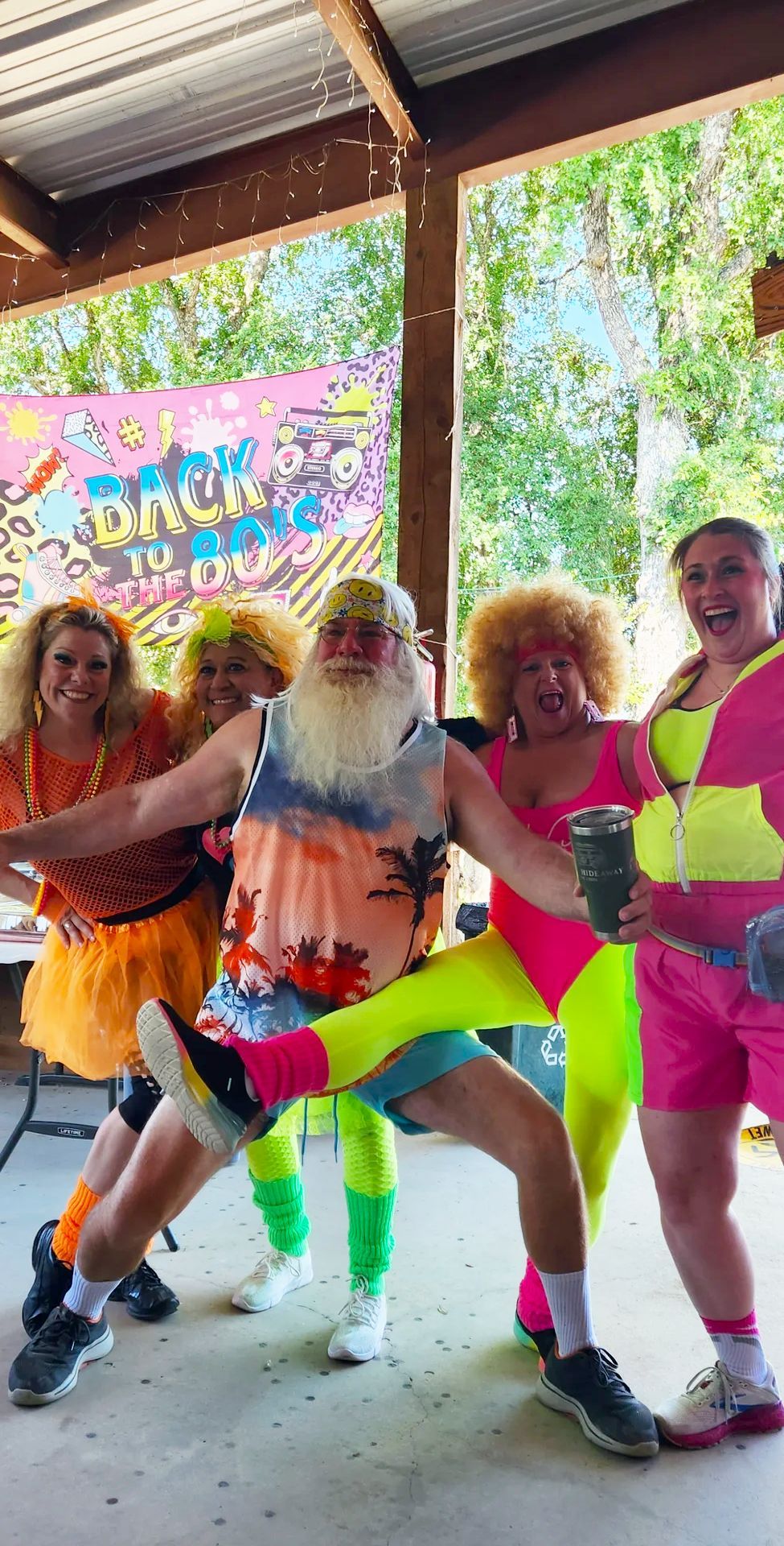 A group of people dressed in neon clothes are posing for a picture.