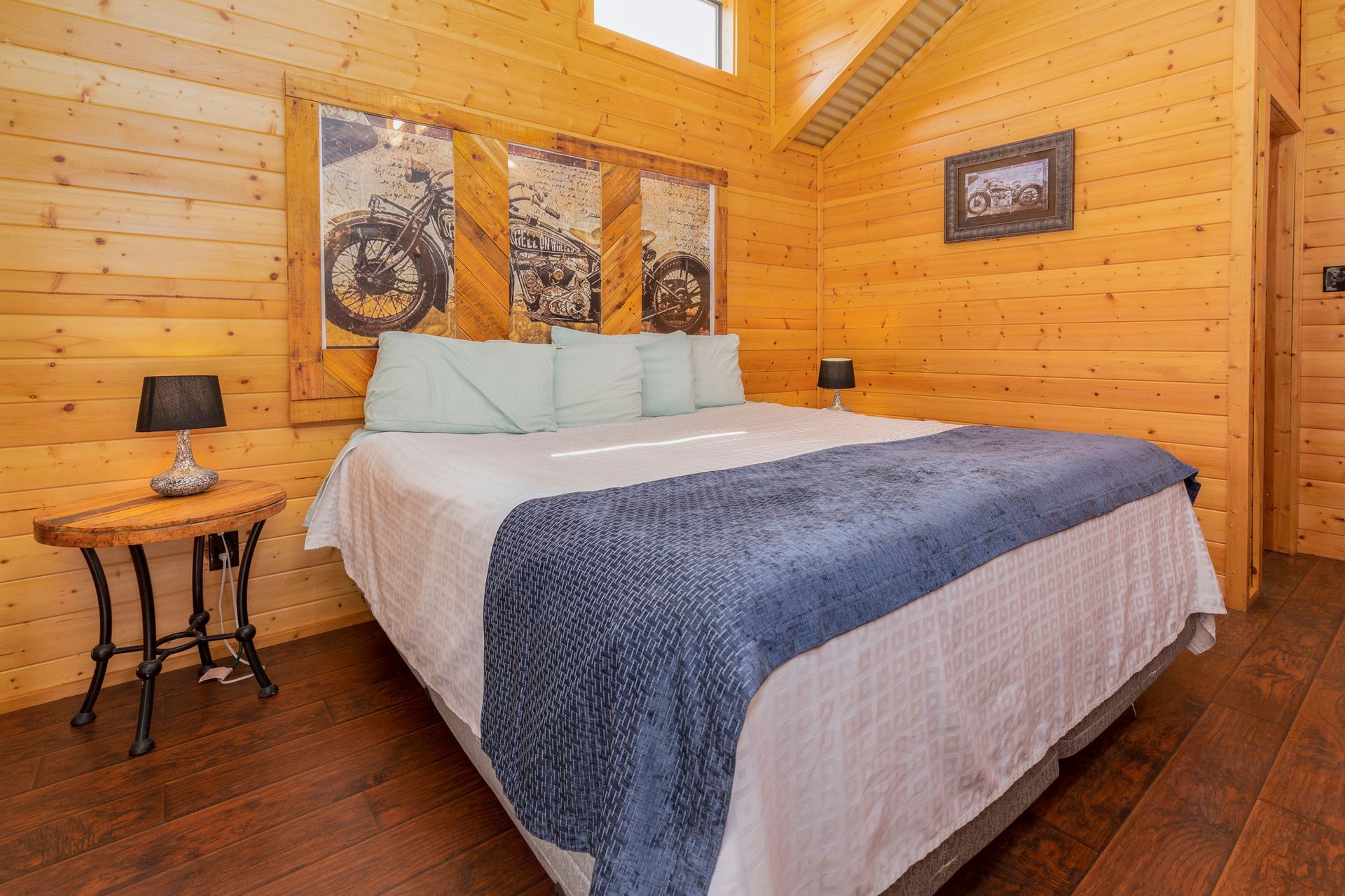 A bedroom in a log cabin with a king size bed and a nightstand.