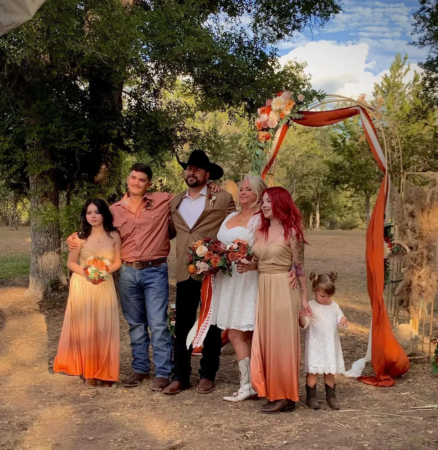 A group of people posing for a picture at a wedding