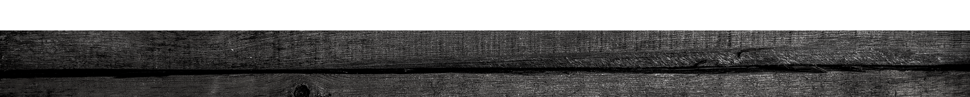 Close-up of a dark, weathered wooden surface with horizontal slats and a gray band across the middle