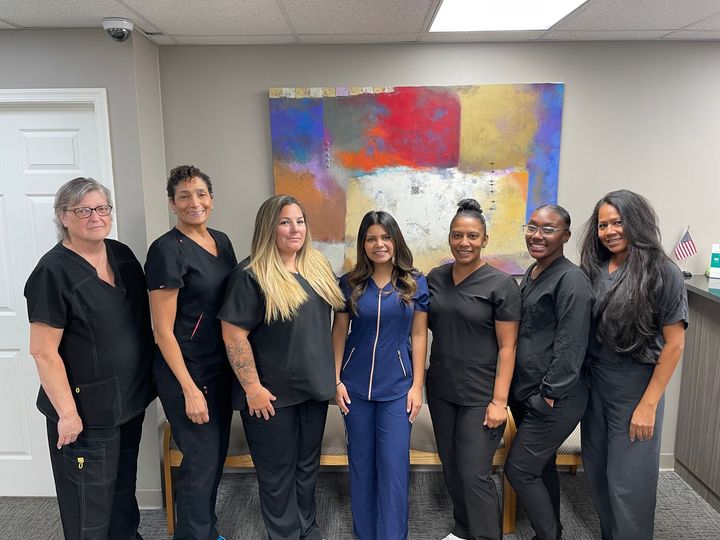 A group of women in scrubs are posing for a picture.