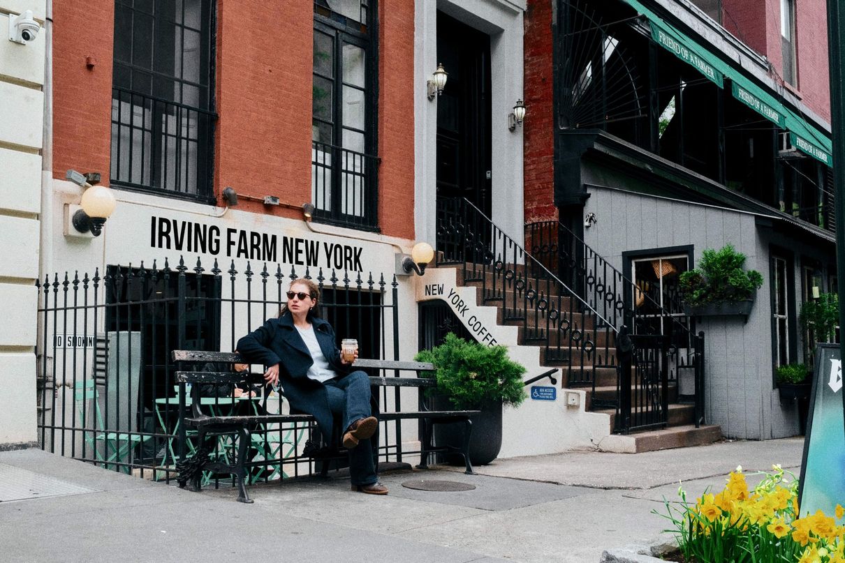 A man sits at a table outside of irving farm coffee roasters