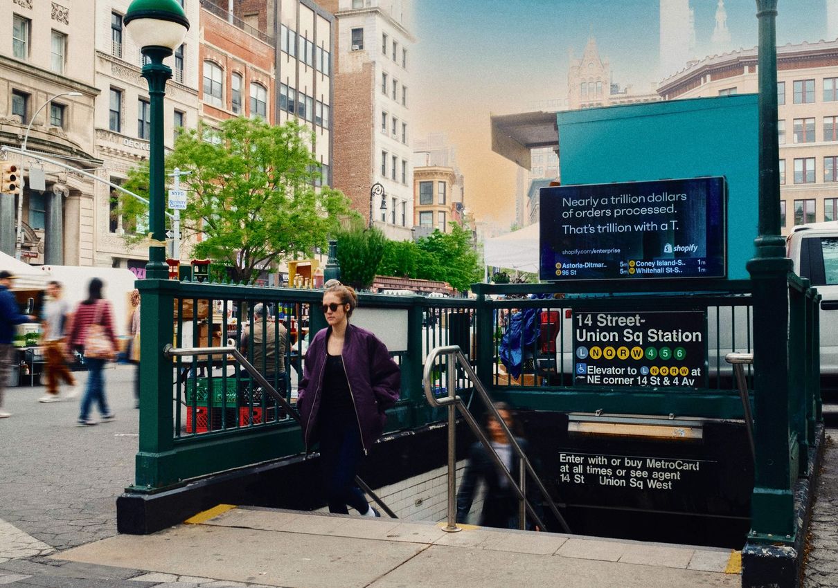 A woman is walking out of a subway station