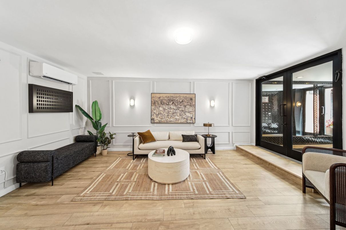 A living room filled with furniture and a large mirror.