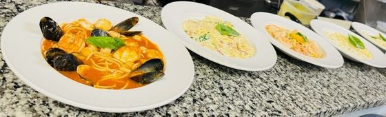 Three plates of food are sitting on a wooden table.