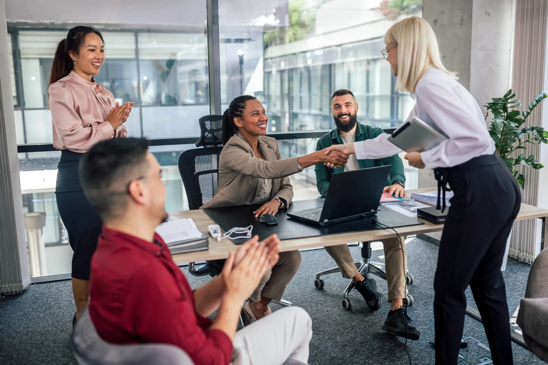A group of people are sitting around a table in a conference room.