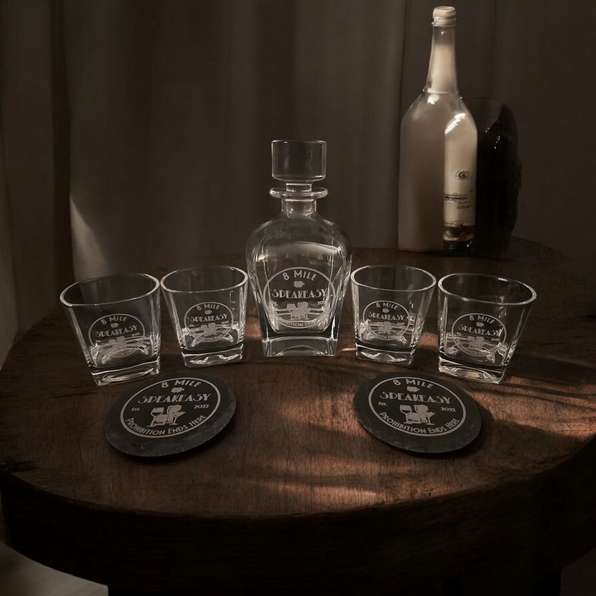 A decanter and shot glasses on a wooden table