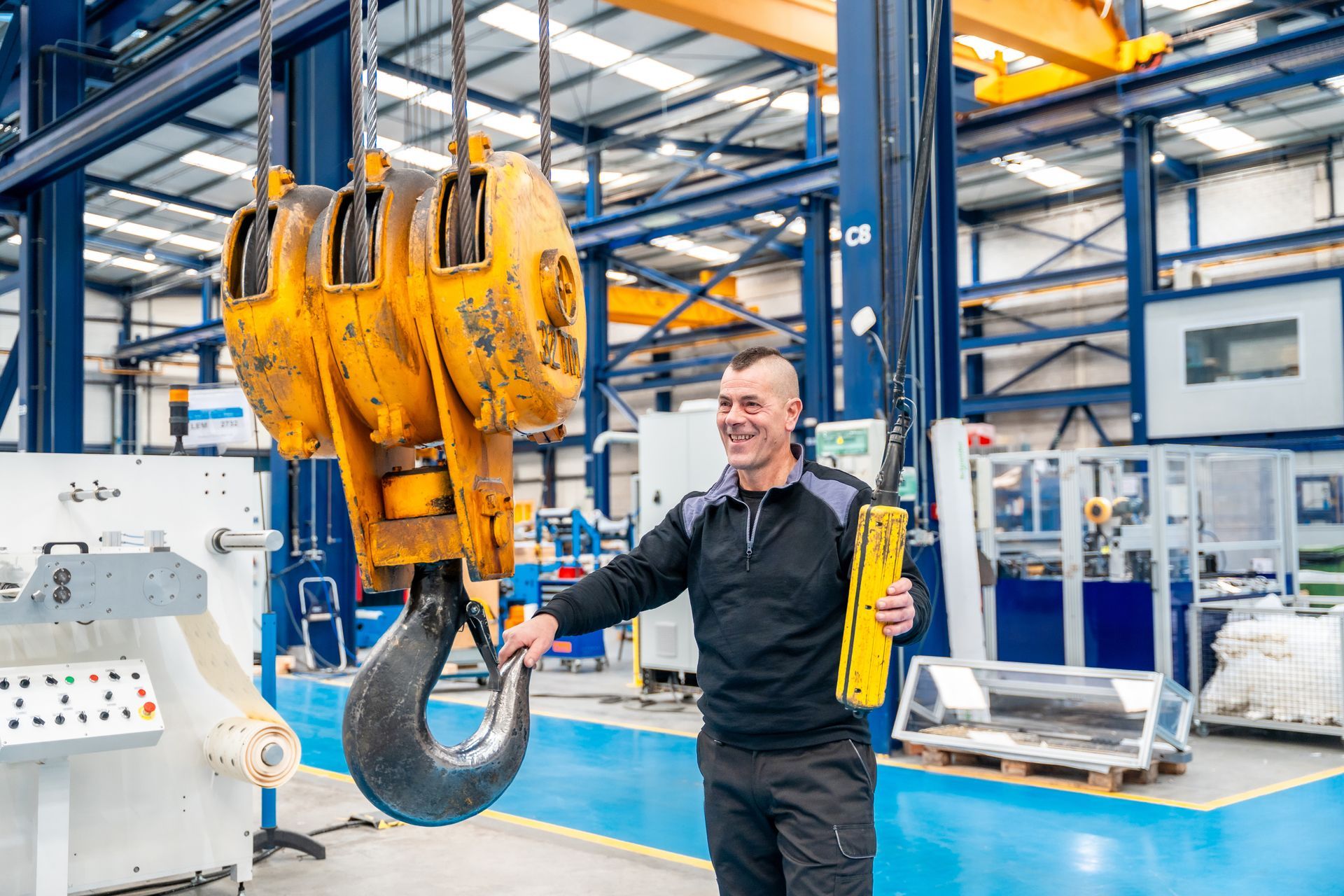 Worker in a logistics center using an industrial crane.