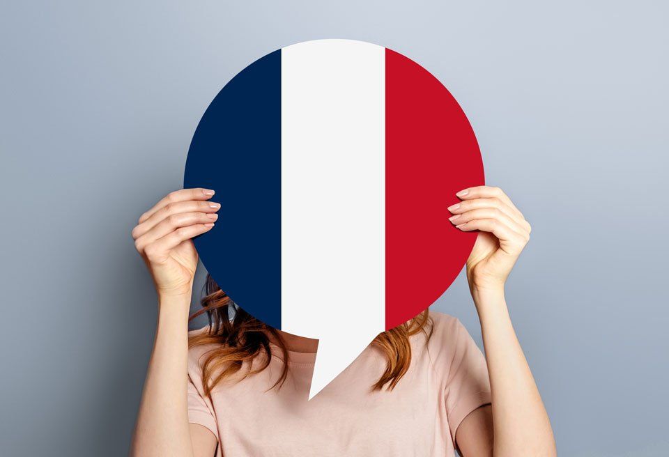 Frau hält Sprechblase mit französischer Flagge