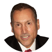 A man in a suit and tie is smiling for the camera