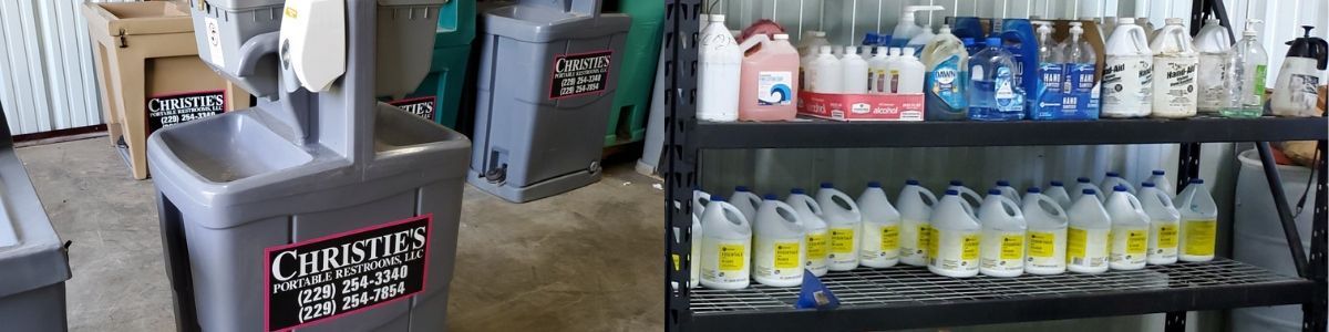 A portable grey sink station stands next to a metal shelf stocked with various bottles of cleaning supplies.