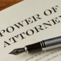 A fountain pen is sitting on top of a power of attorney.