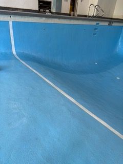 An empty swimming pool with a white line on the floor.