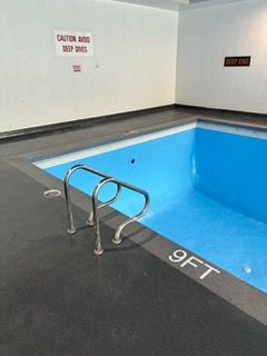 A large indoor swimming pool with a staircase leading to it.