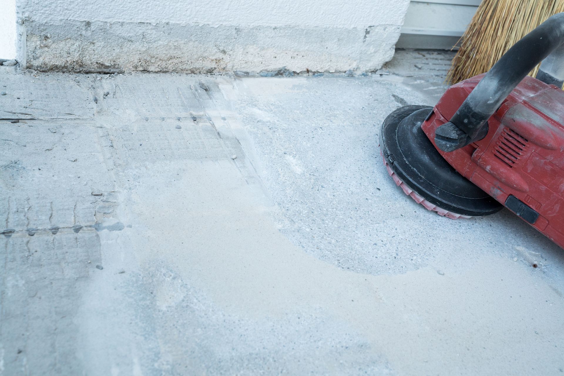 A person is using a grinder on a concrete floor.
