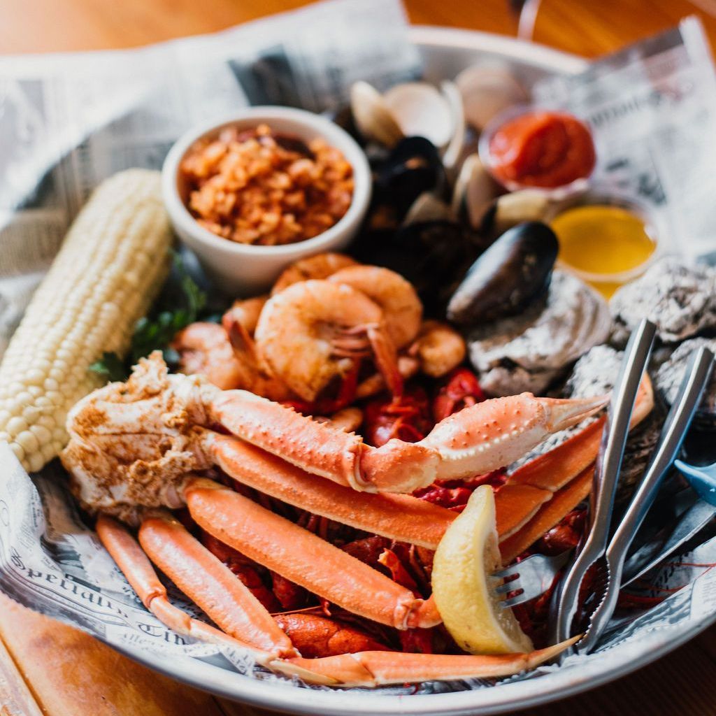 a plate of seafood including crab legs , shrimp , mussels and corn on the cob .