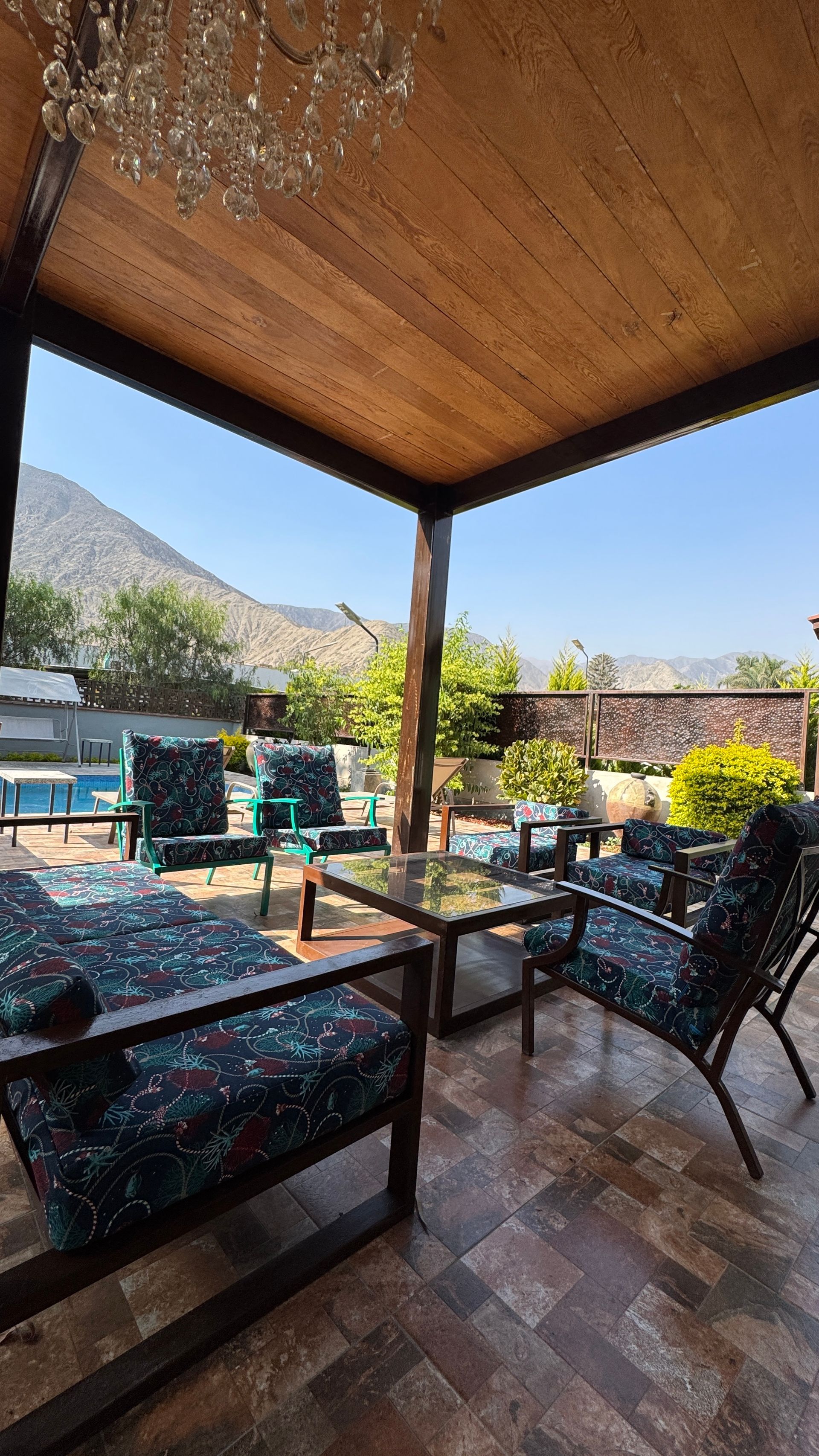 Patio with seating area and view of mountains and pool.