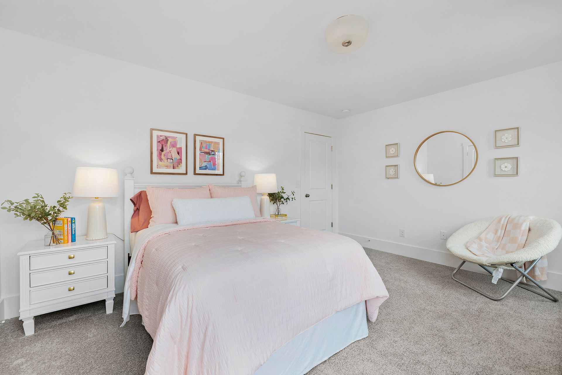 A bedroom with a bed , nightstand , chair and mirror.