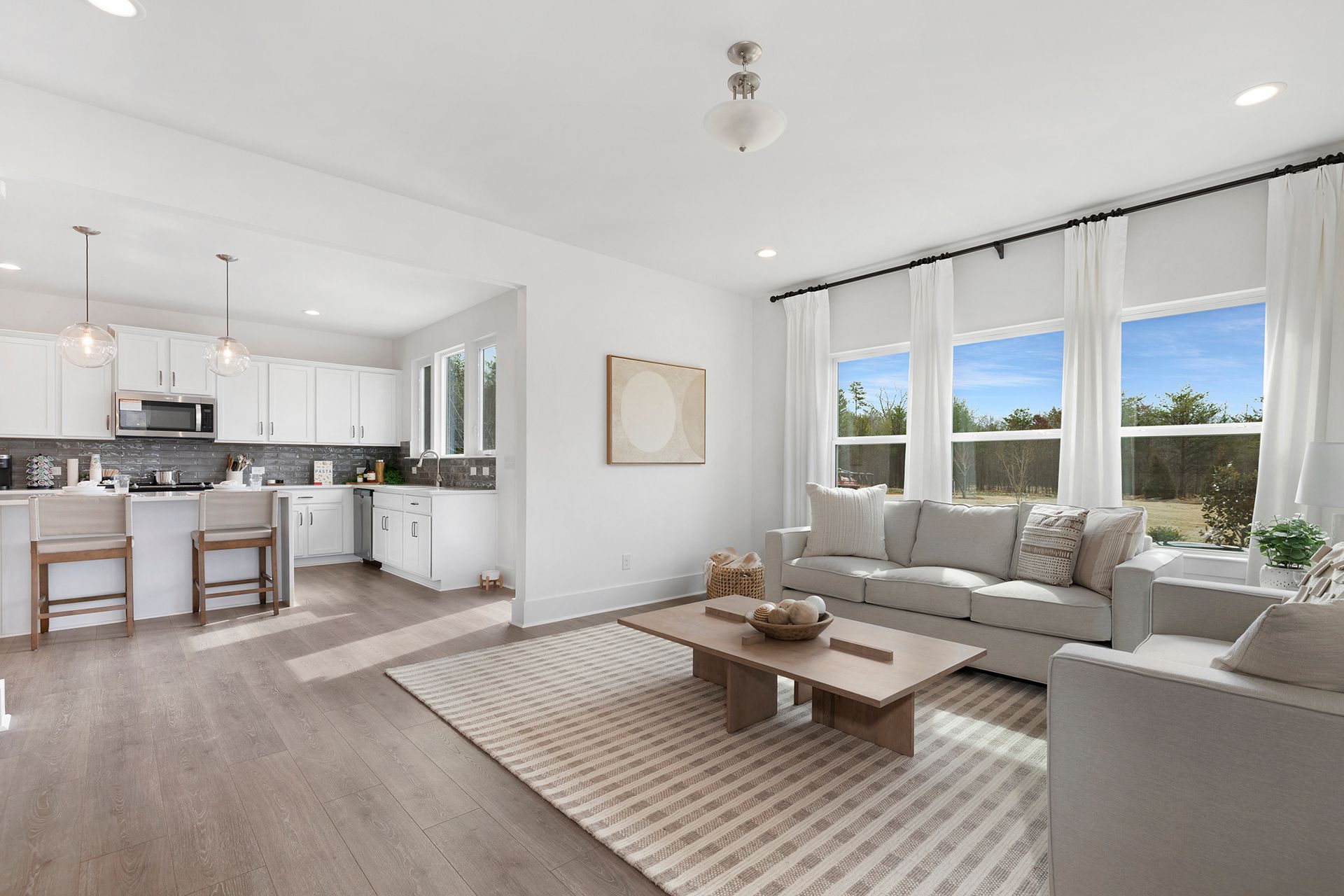 A living room with a couch , chairs , a coffee table and a rug.