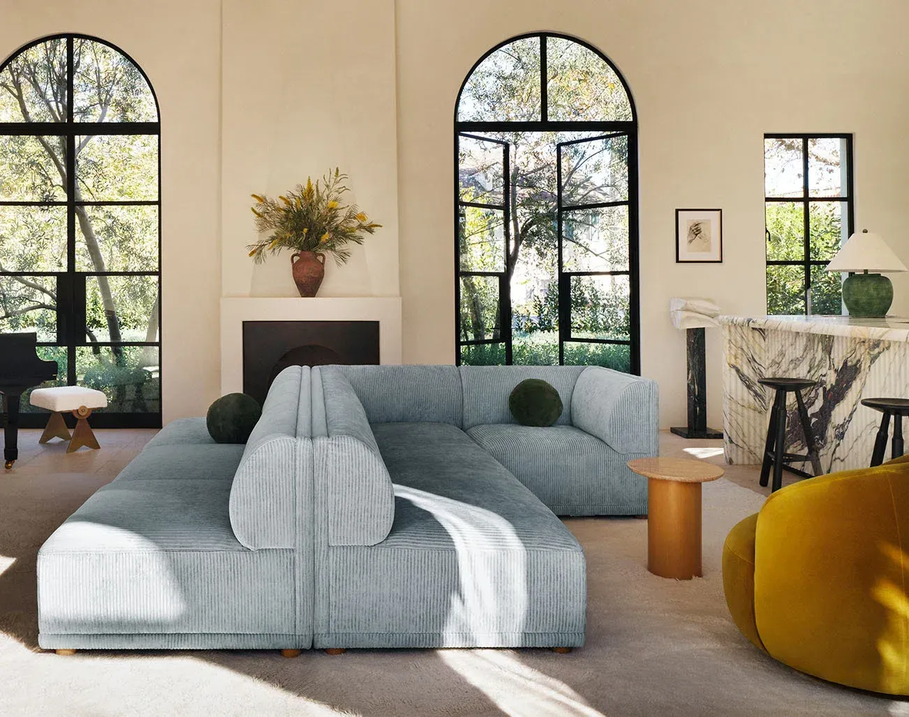 A living room with a large sectional couch and a fireplace.