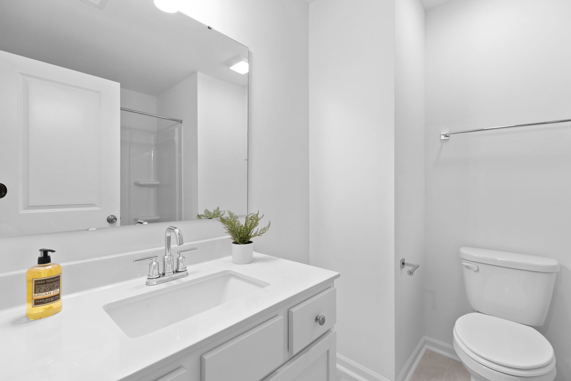 A bathroom with a sink , toilet and mirror.