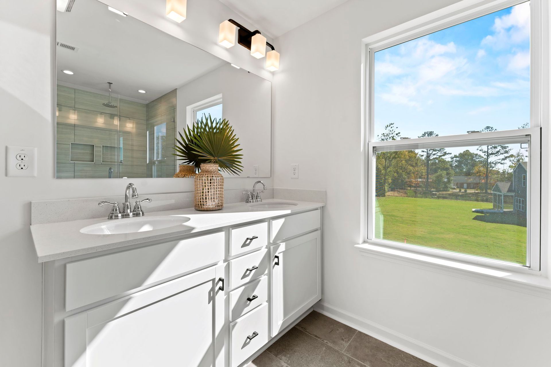 a bathroom with two sinks , a large mirror and a window .