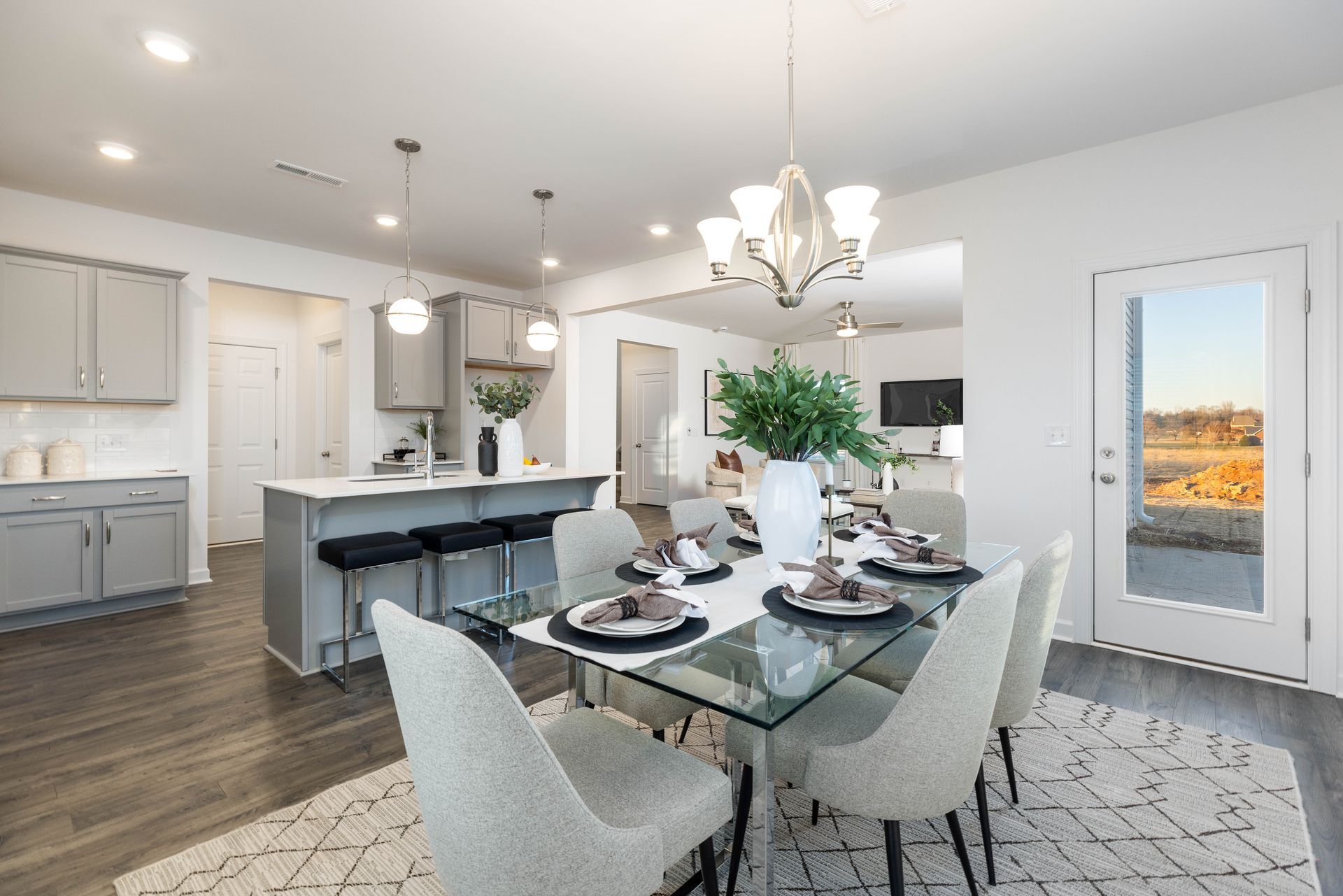 A dining room with a glass table and chairs in a house.