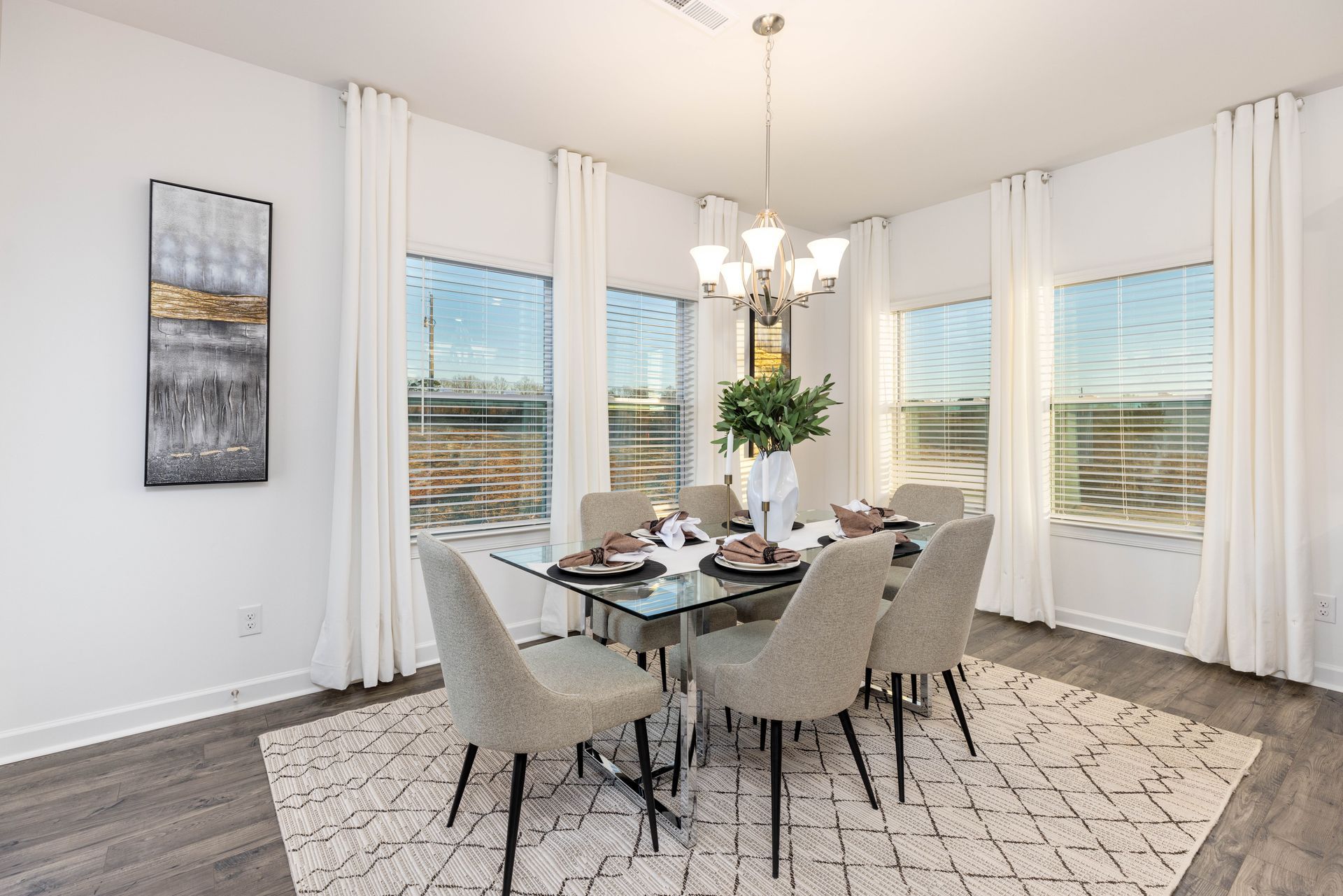A dining room with a table and chairs and a chandelier.