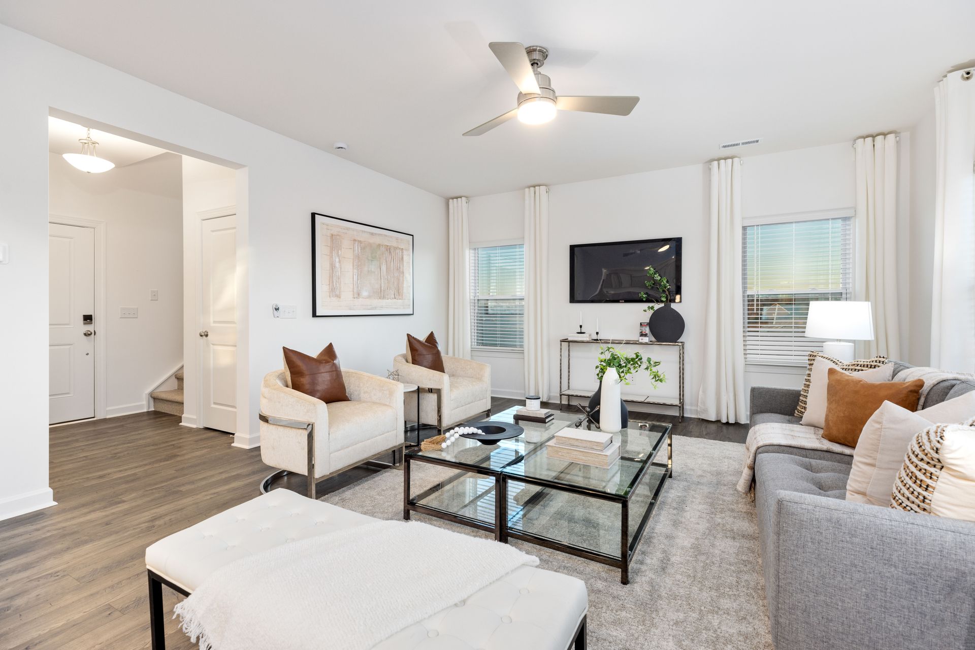 A living room with two couches , a coffee table , and a ceiling fan.