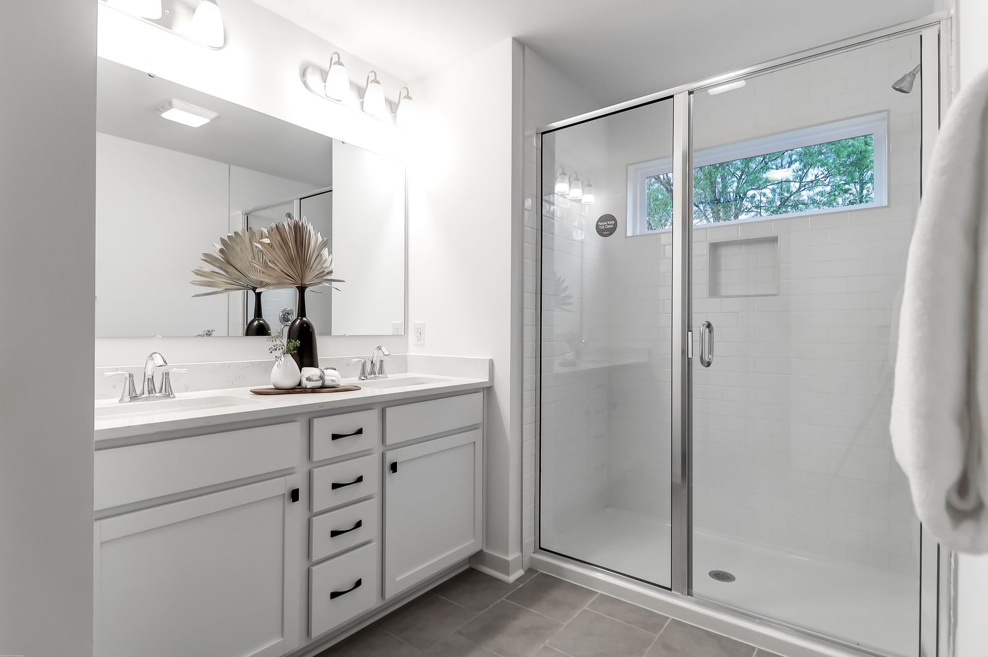 A bathroom with two sinks and a walk in shower.