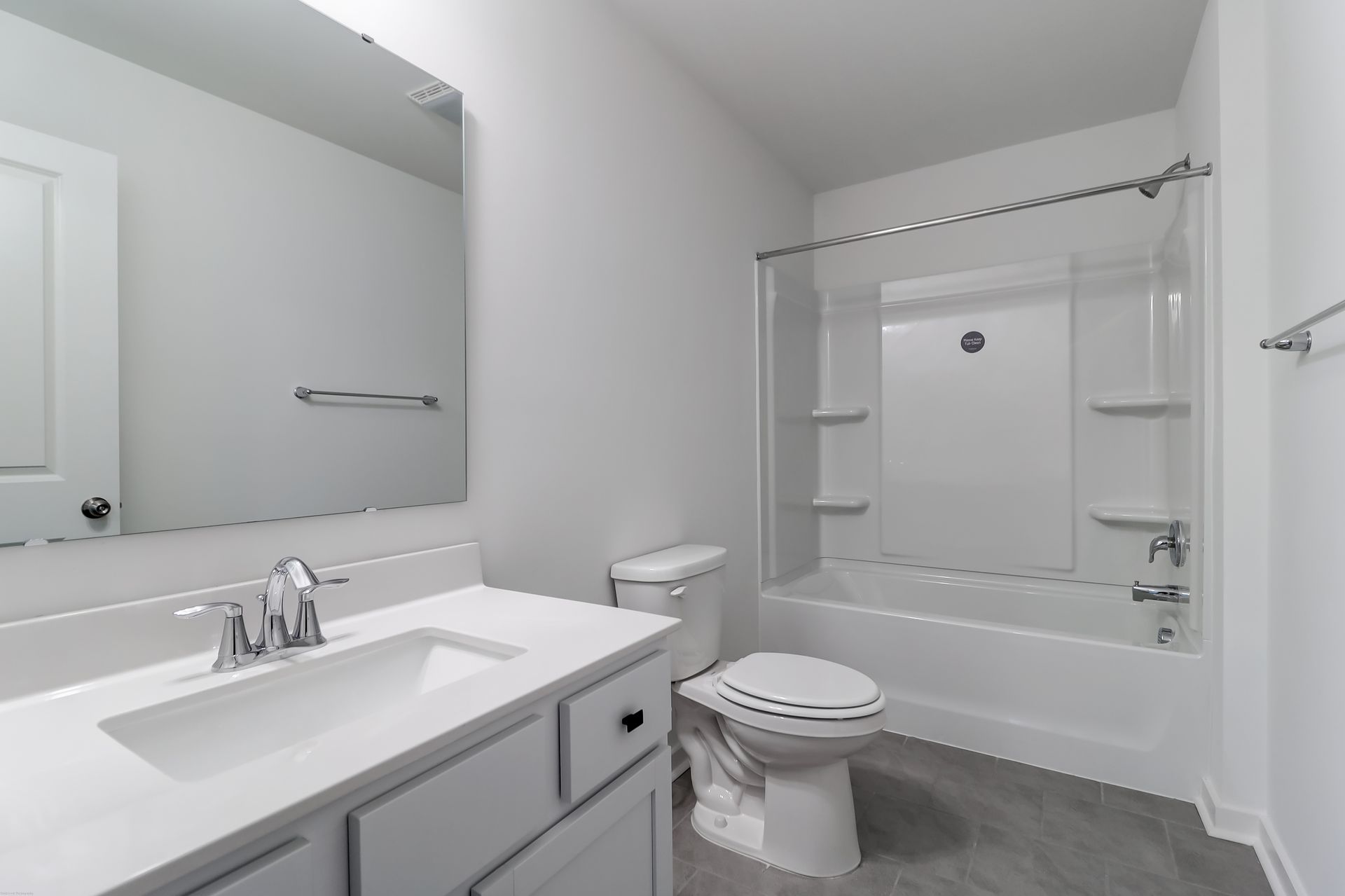 A bathroom with a sink , toilet , tub and mirror.