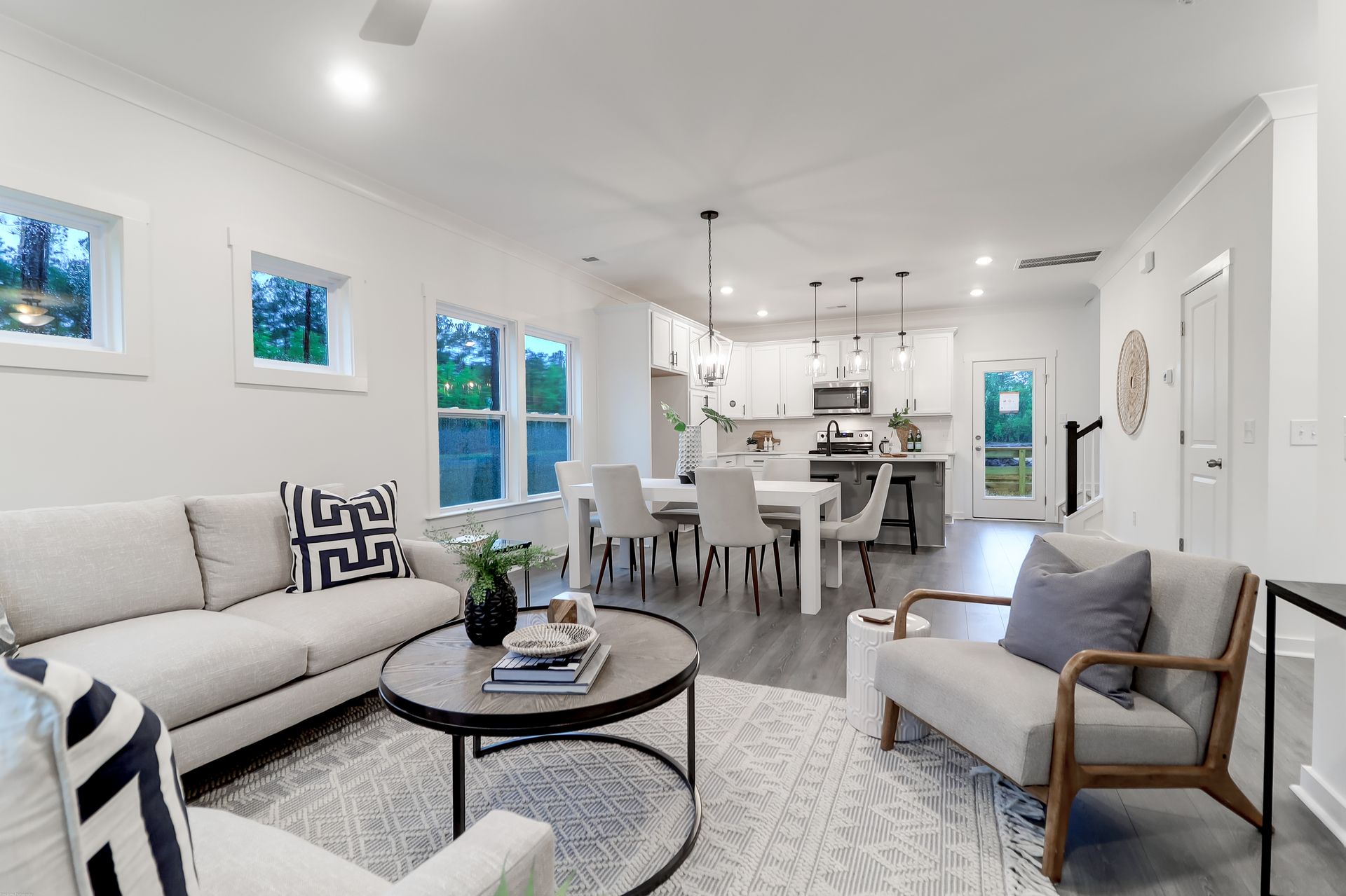 A living room with a couch , chairs , and a coffee table.