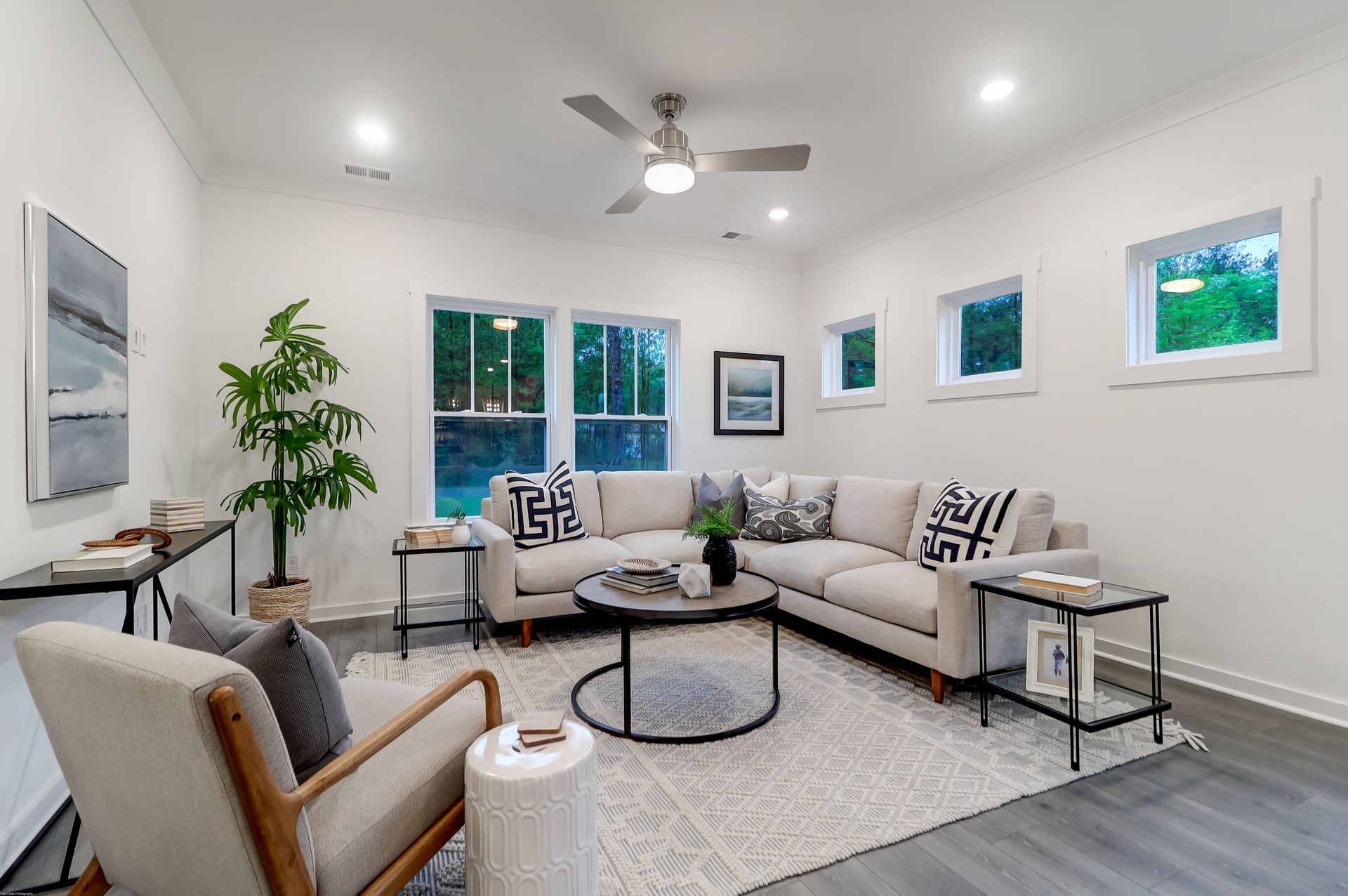 A bedroom with a bed , bench , rug and windows.
