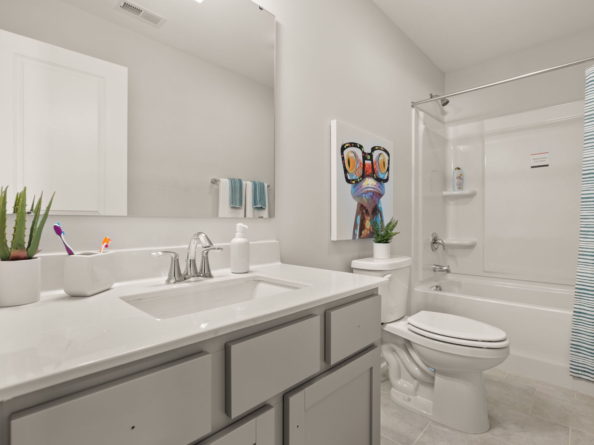 A bathroom with a sink , toilet , tub and mirror.