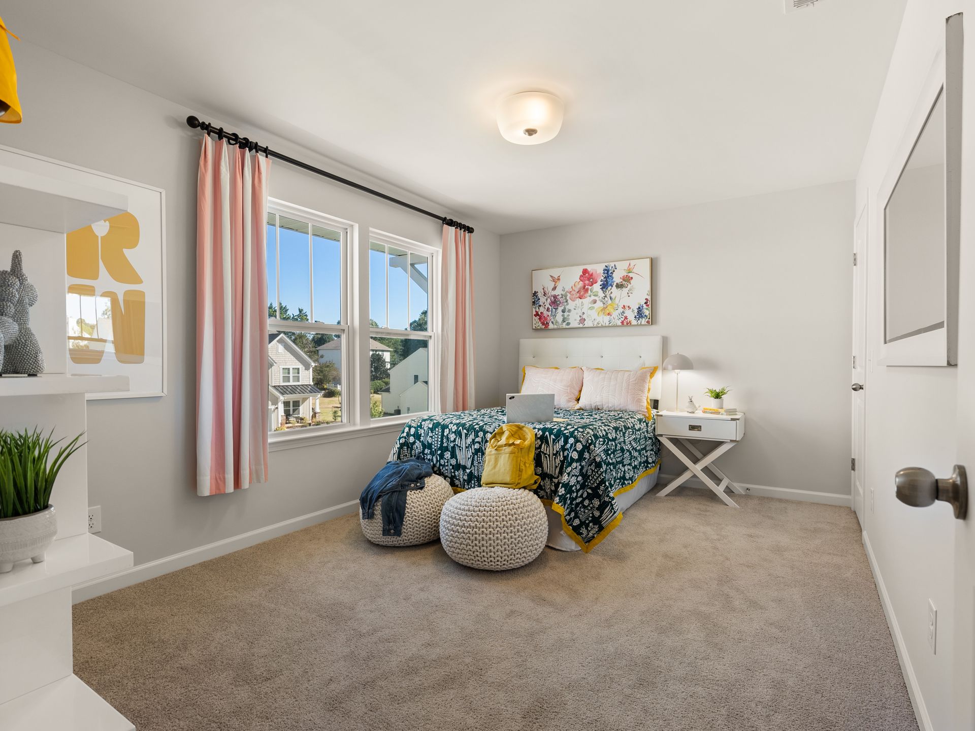 A bedroom with a bed , two windows and a television.