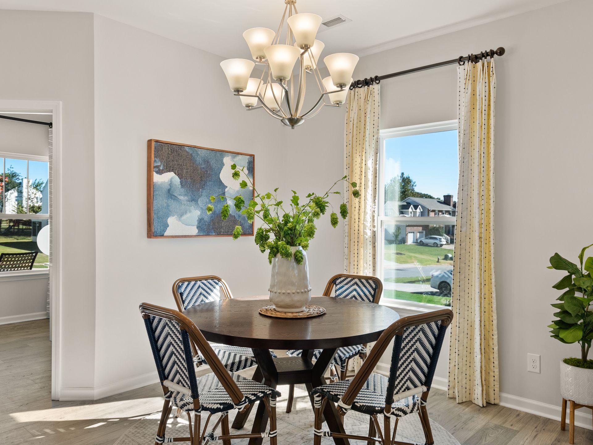 A dining room with a round table and chairs and a chandelier.