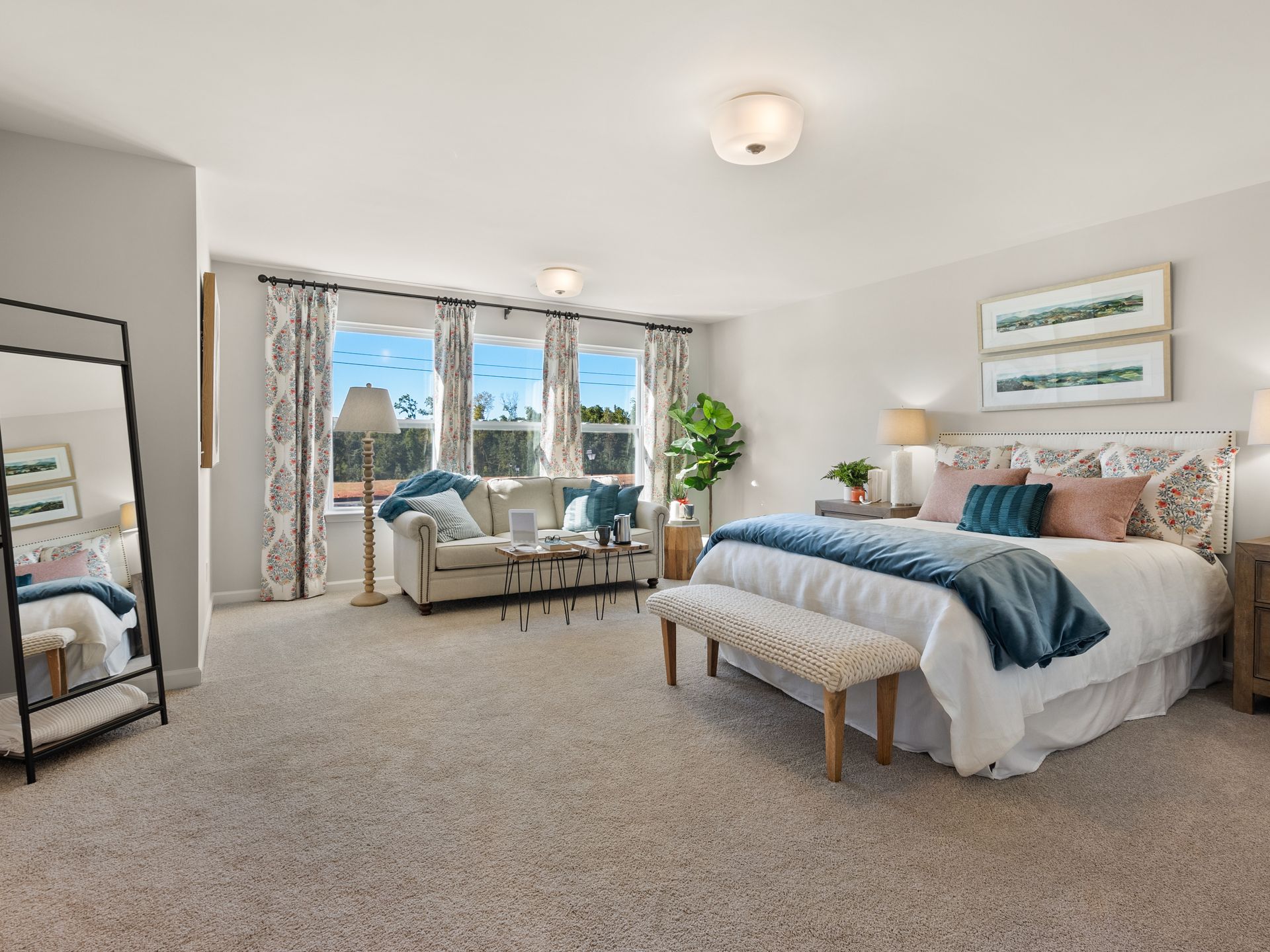 A bedroom with a large bed , couch , and mirror.