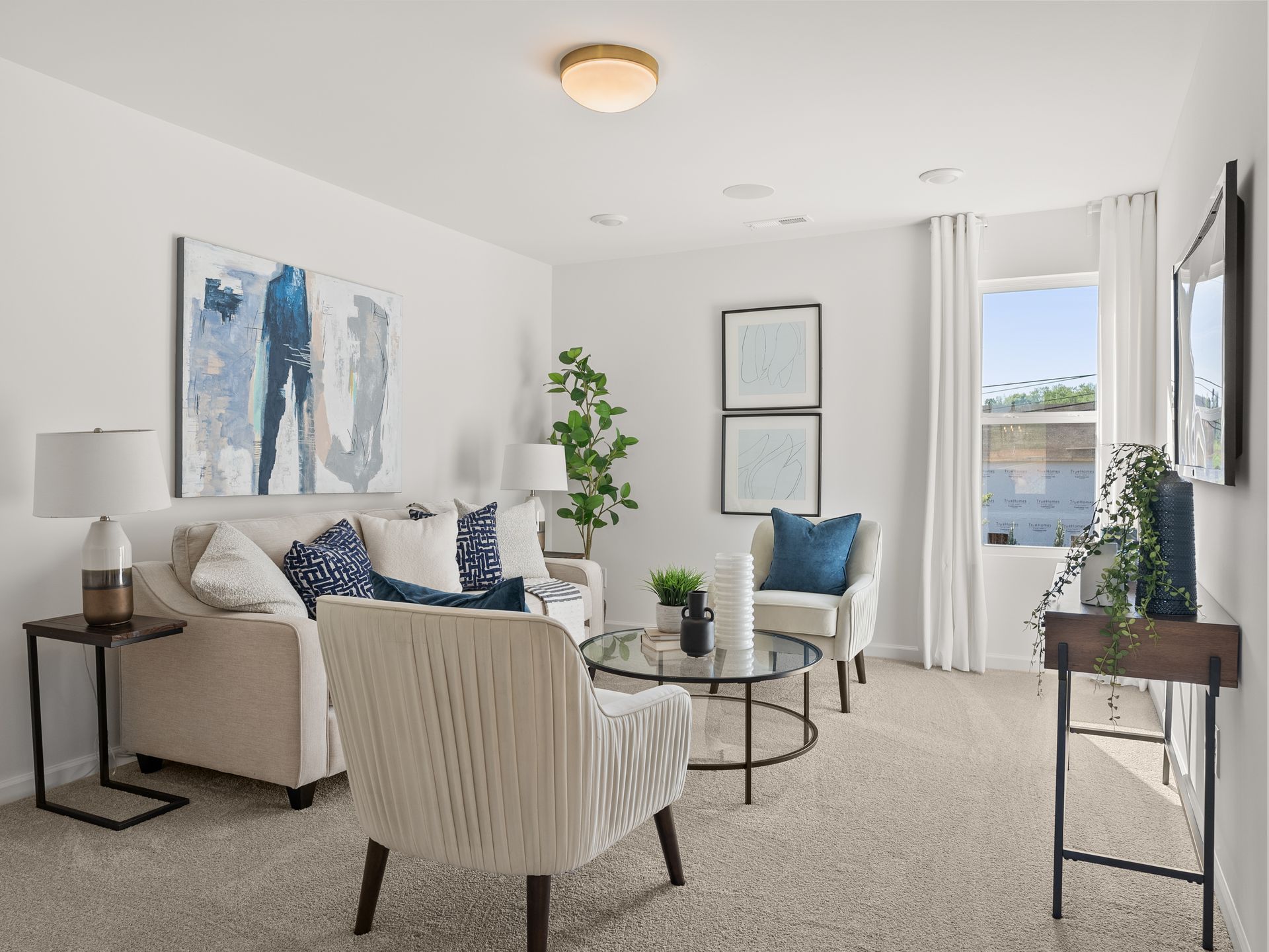 A living room with a couch , chairs , a table and a television.